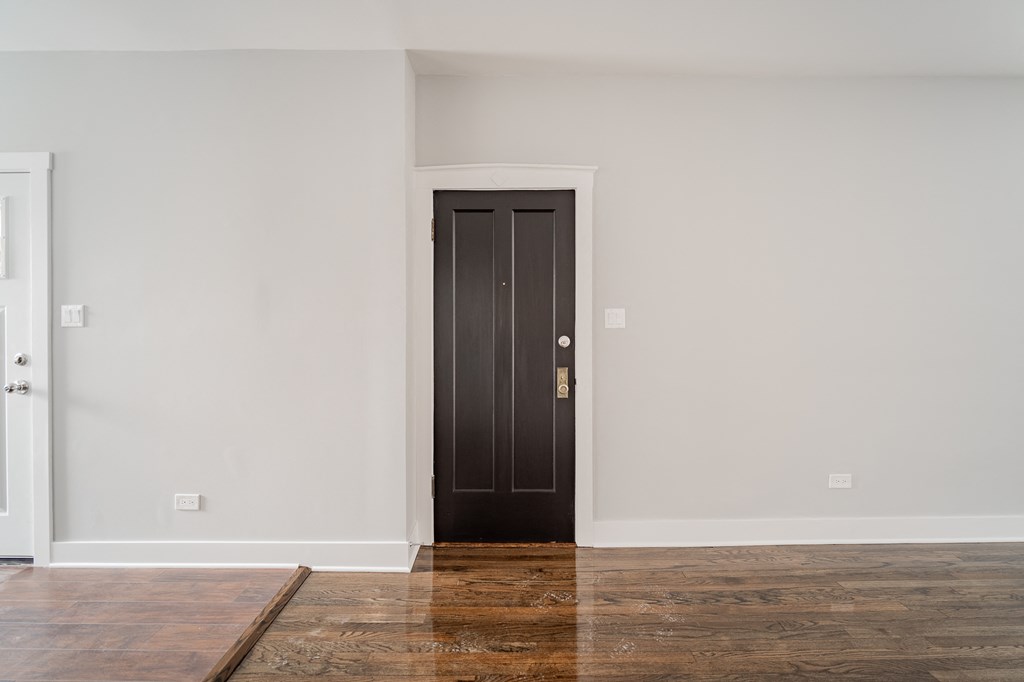 a room with white walls and a black door