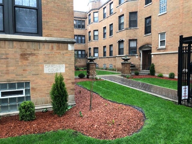 an apartment building with a green yard and grass