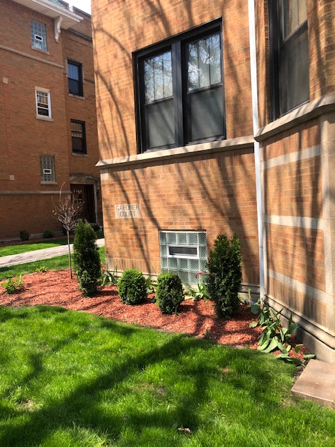 a garden in front of a brick building