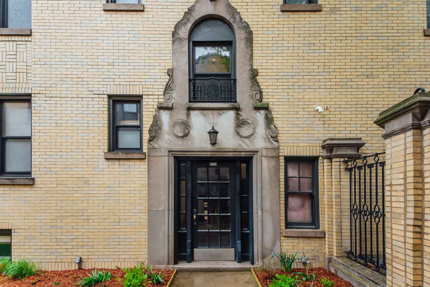 a brick building with a black door and a window