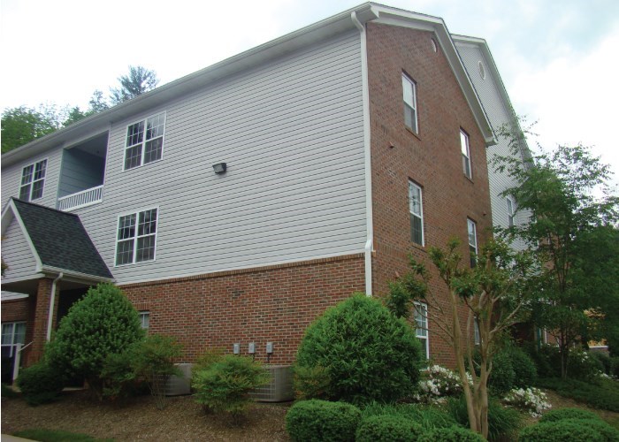 the side of a house with a brick and white siding