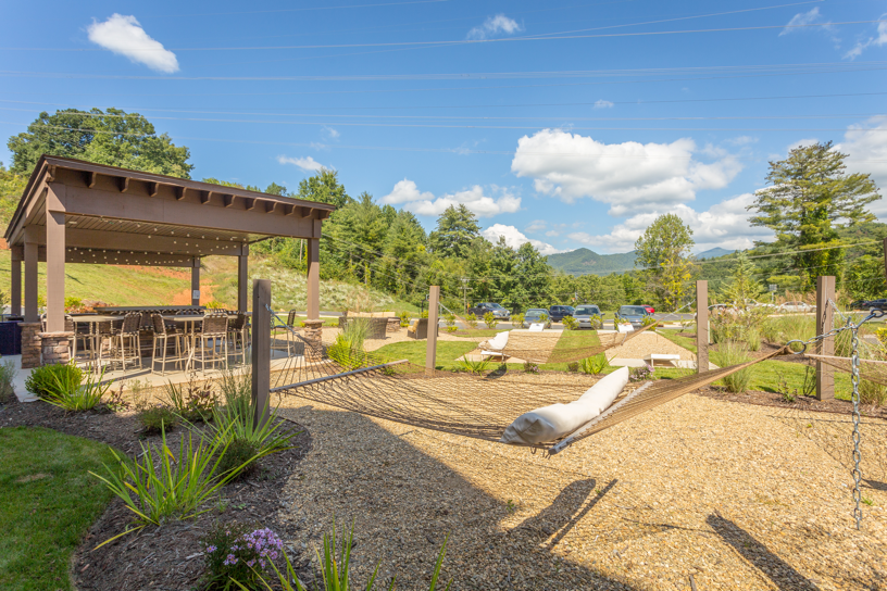 a view of a backyard with a hammock and a pergola