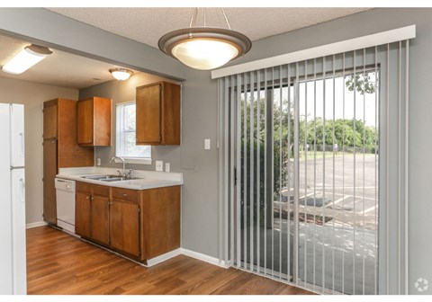 a kitchen with a sliding glass door leading to a patio