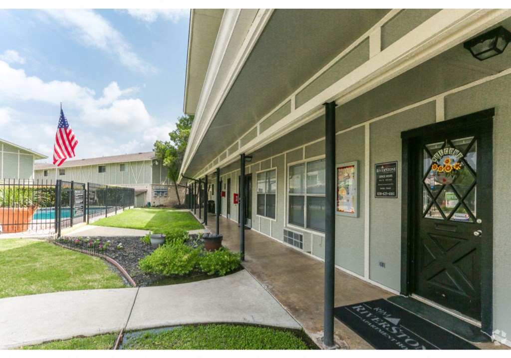 a view of the front of a building with an flag in the yard