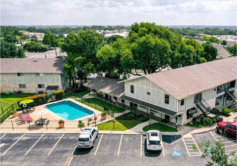 an aerial view of a house with a swimming pool and a parking lot