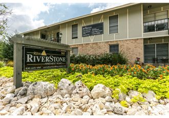 an apartment building with a riverstone sign in front