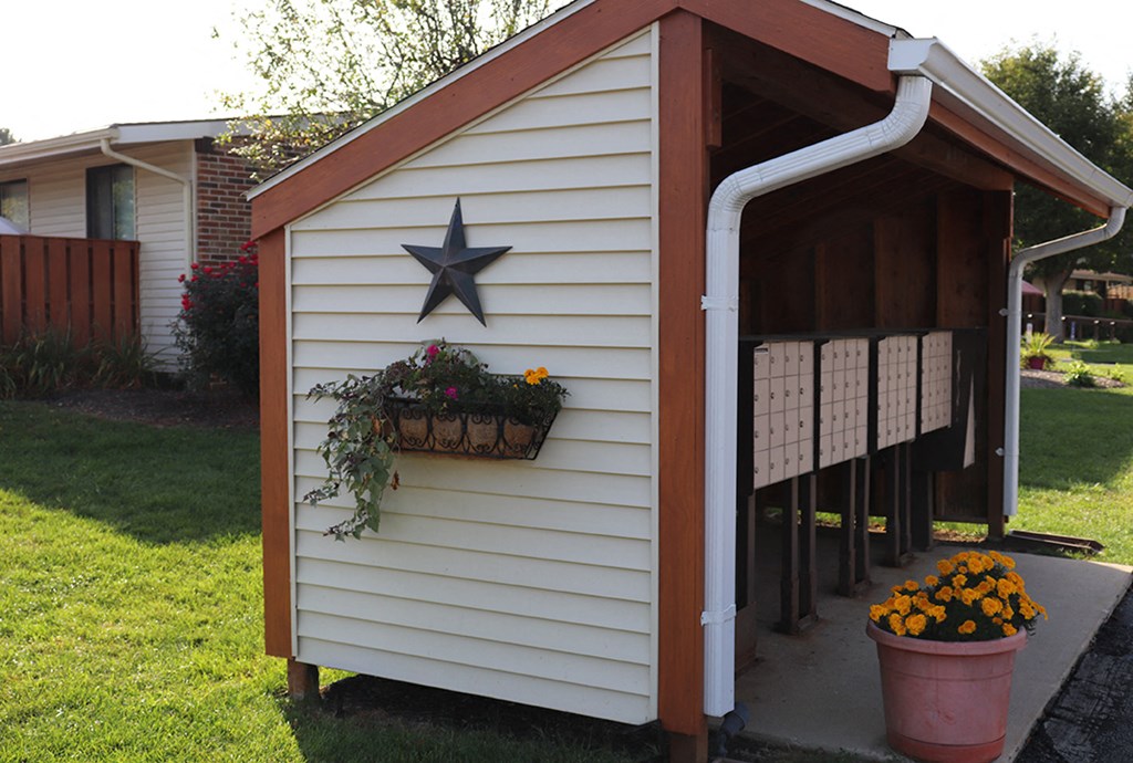 a shed with a star on it and a basket of flowers on it
