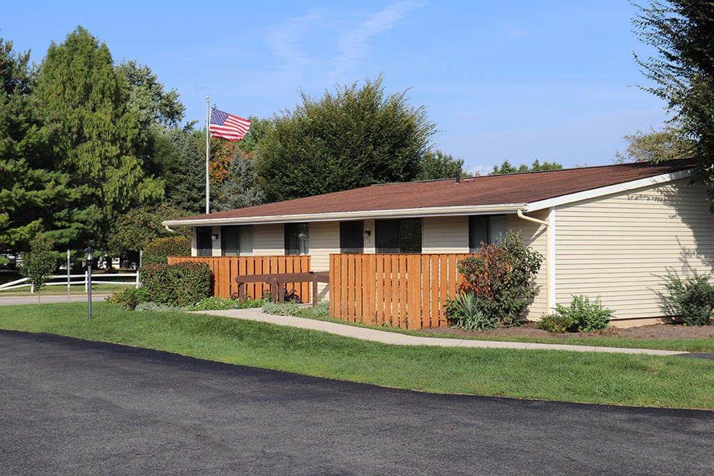 a white house with a wooden fence and an flag