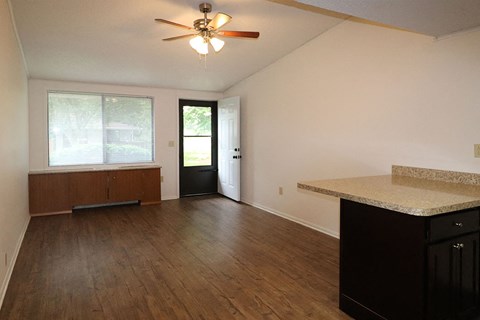an empty living room with hard wood floors and a ceiling fan