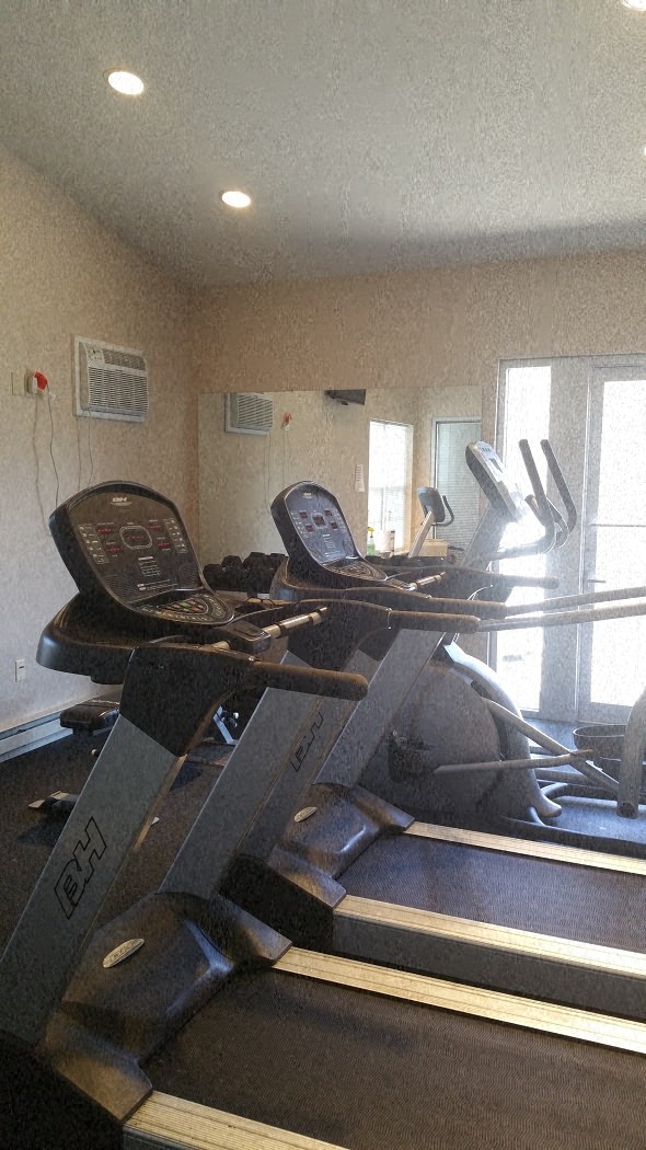 A treadmill and a stationary bike are in a home gym.