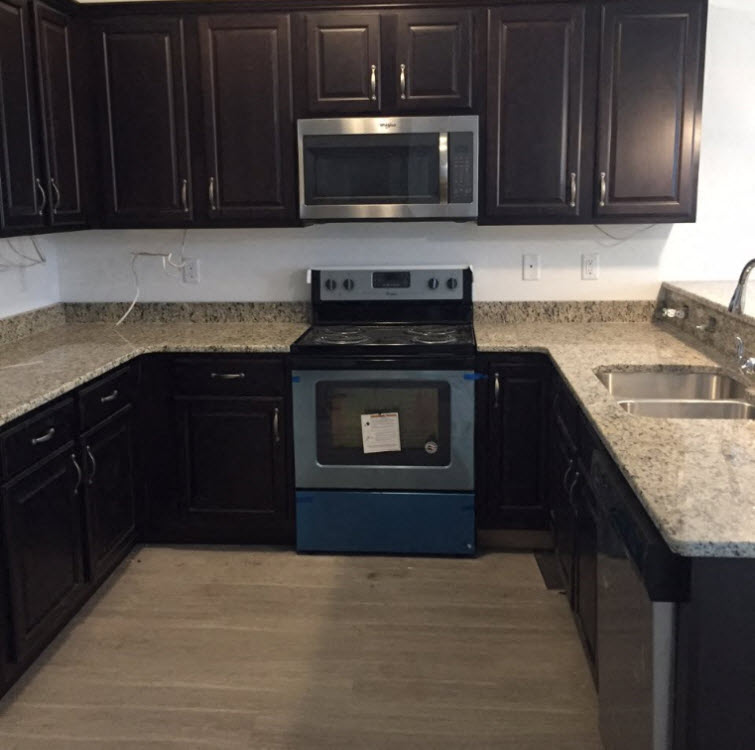 A kitchen with a black oven and microwave.