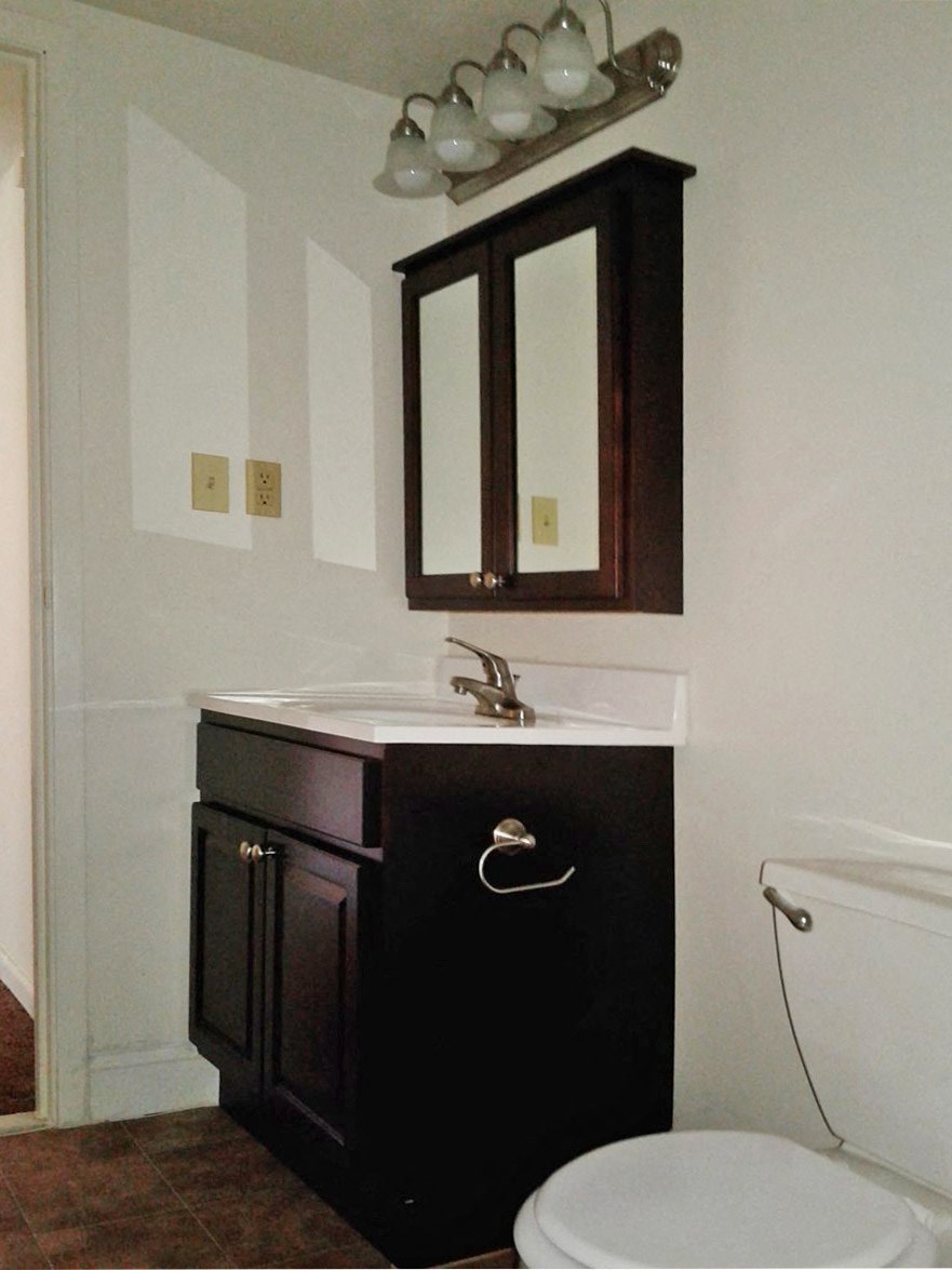 a bathroom with a toilet and a sink and a mirror