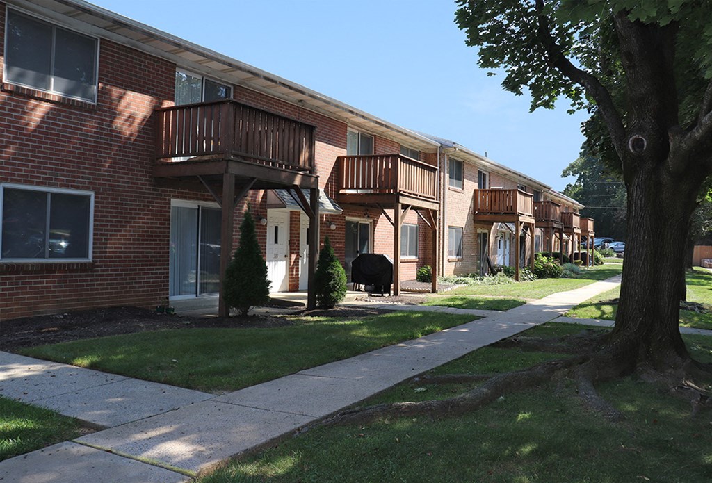 a row of brick apartment buildings with wooden balconies and sidewalks