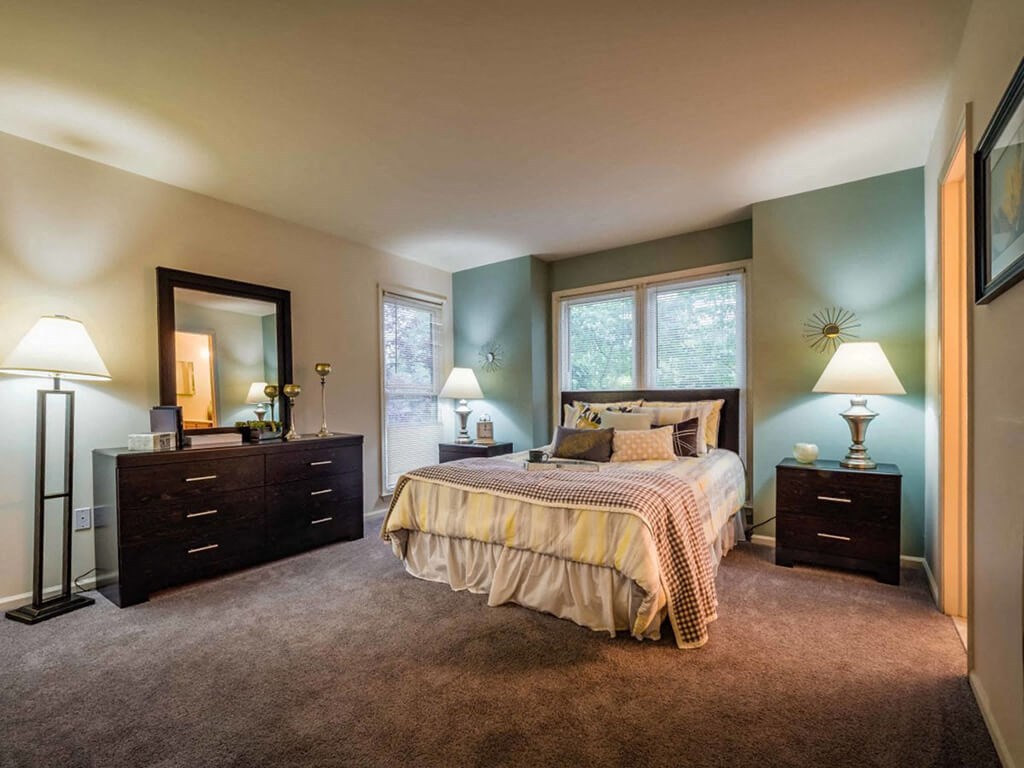 a bedroom with a bed and two dressers