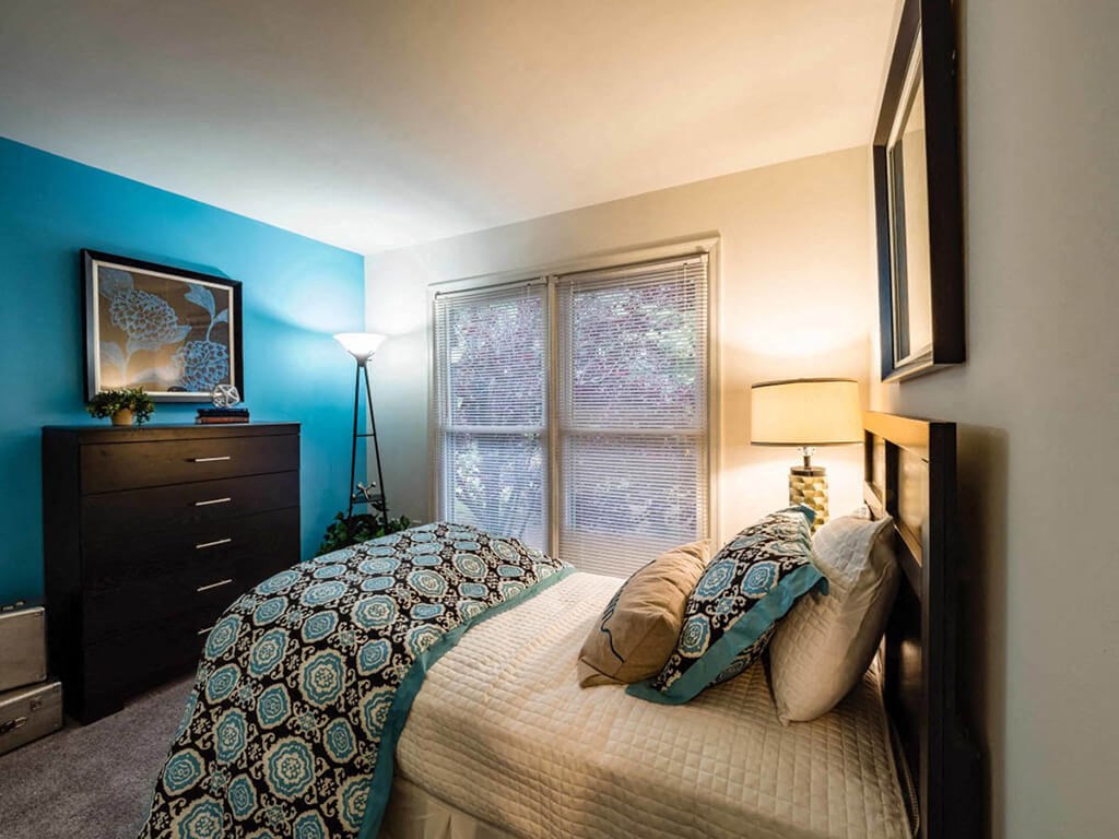 a bedroom with a bed and a dresser and a window