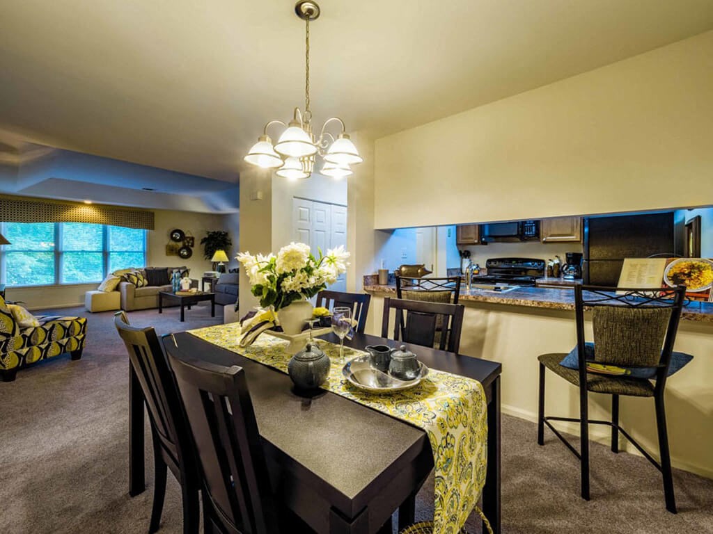 a dining room and kitchen with a table and chairs
