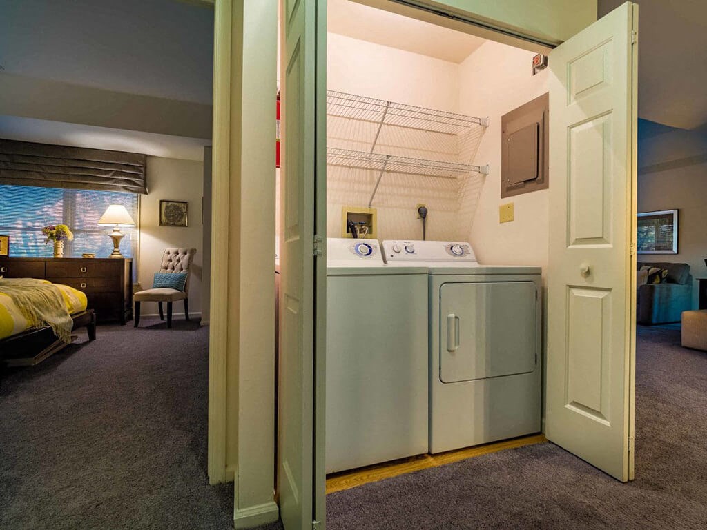 a washer and dryer in a room next to a bedroom