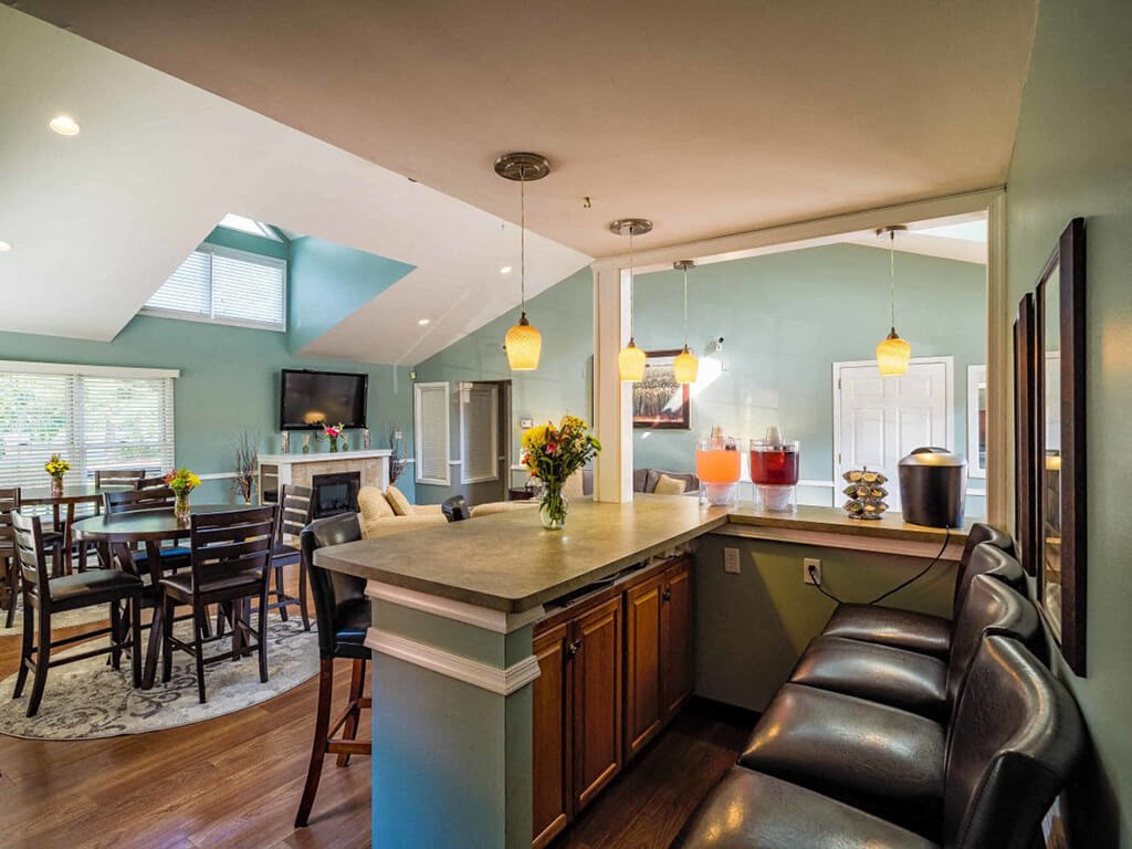 a kitchen with a bar and a dining room with a table and chairs