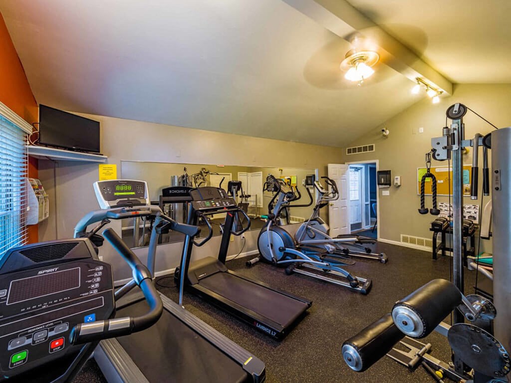 a gym with weights and cardio equipment at the retirement home