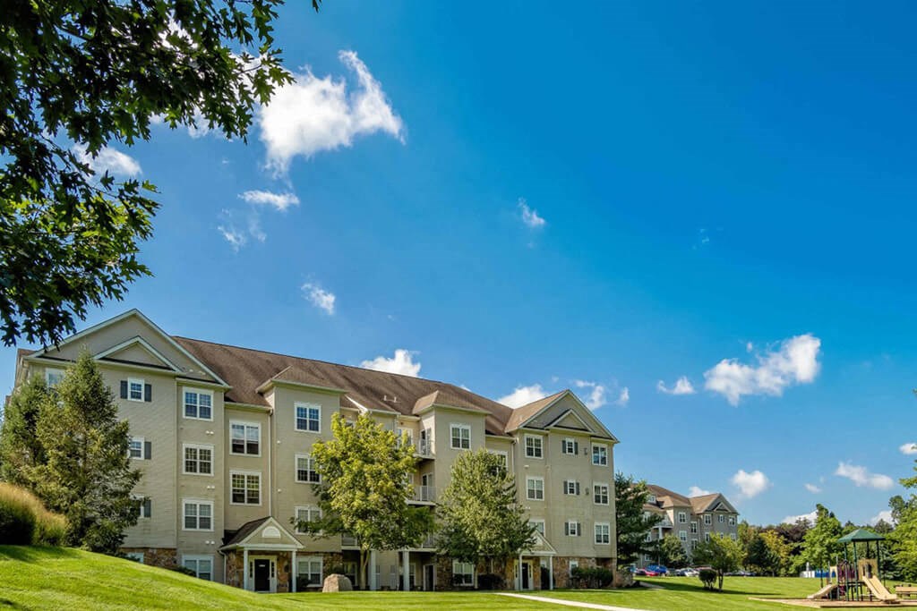 a large apartment building on a green lawn