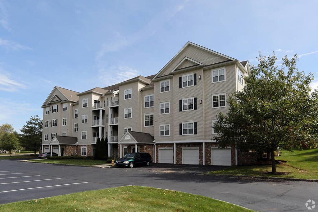 the exterior of an apartment building with a parking lot