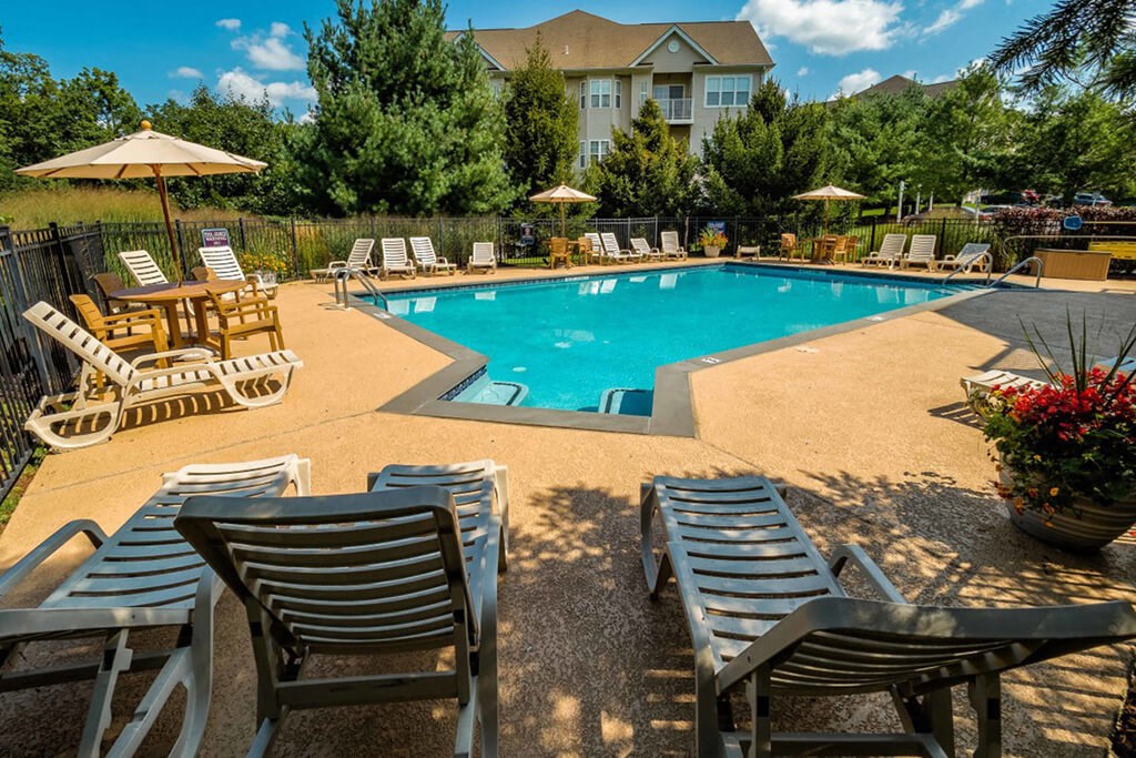 a pool with chairs and umbrellas and a resort style pool