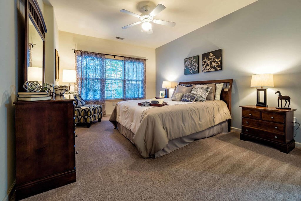 a bedroom with a bed and a ceiling fan
