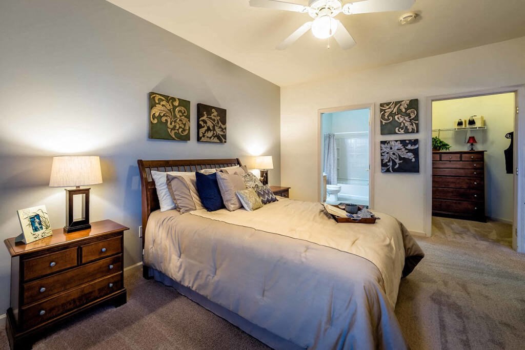 a bedroom with a bed and a ceiling fan