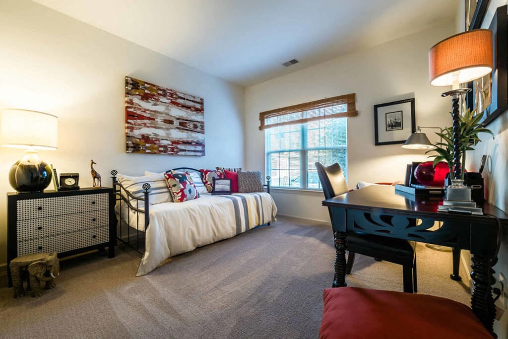 a bedroom with a bed and a desk