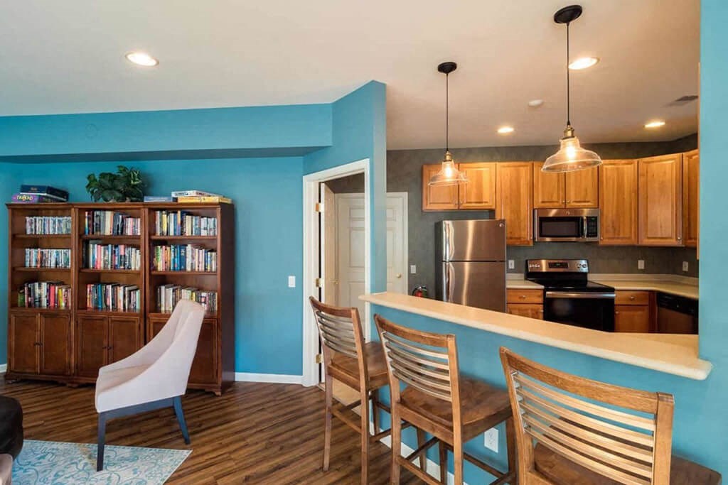 a kitchen and dining room with a bar and a bookcase