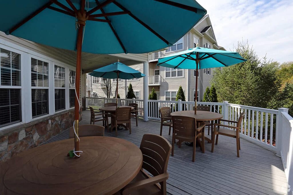 tables and chairs on the deck with umbrellas