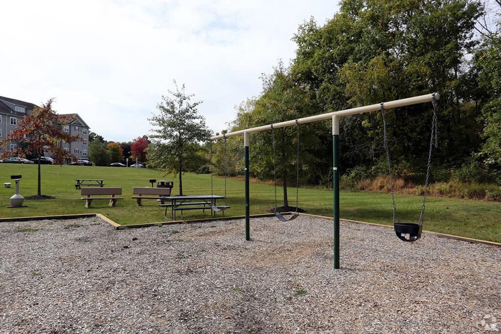 a swing set in a park with benches