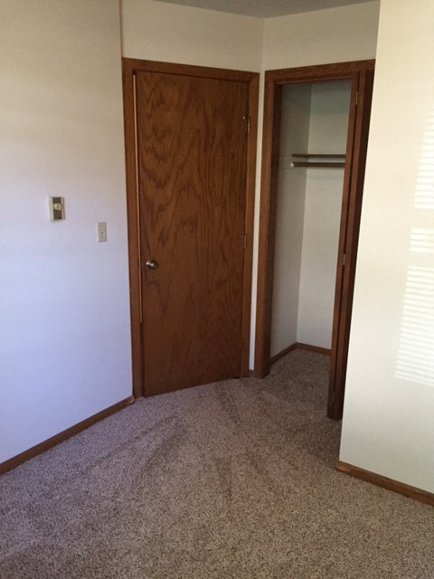 an empty room with a closet and a door