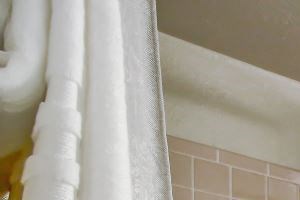 Master bathroom with soaking tub, tile backsplash, large mirror and wood style flooring