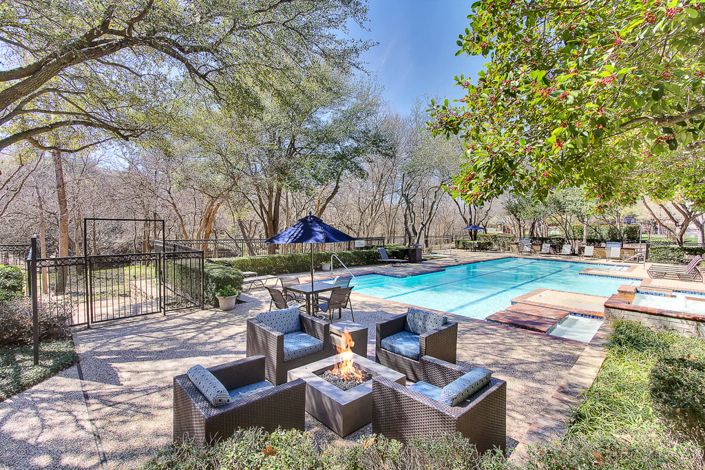 Stunning, tree-lined swimming pool and hot tub with fire pit, tanning deck and lounge seating