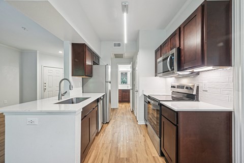 a large kitchen with wooden cabinets and white counter tops and a wood floor