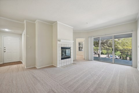 a living room with a fireplace and a door to a balcony