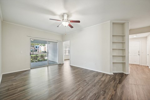 an empty living room with white walls and a ceiling fan