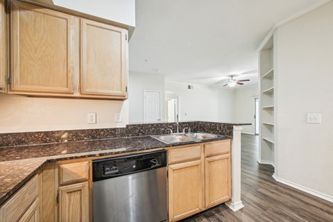 a kitchen with wooden cabinets and a stainless steel dishwasher