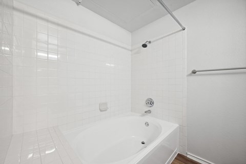 a white bathroom with a large tub and a shower