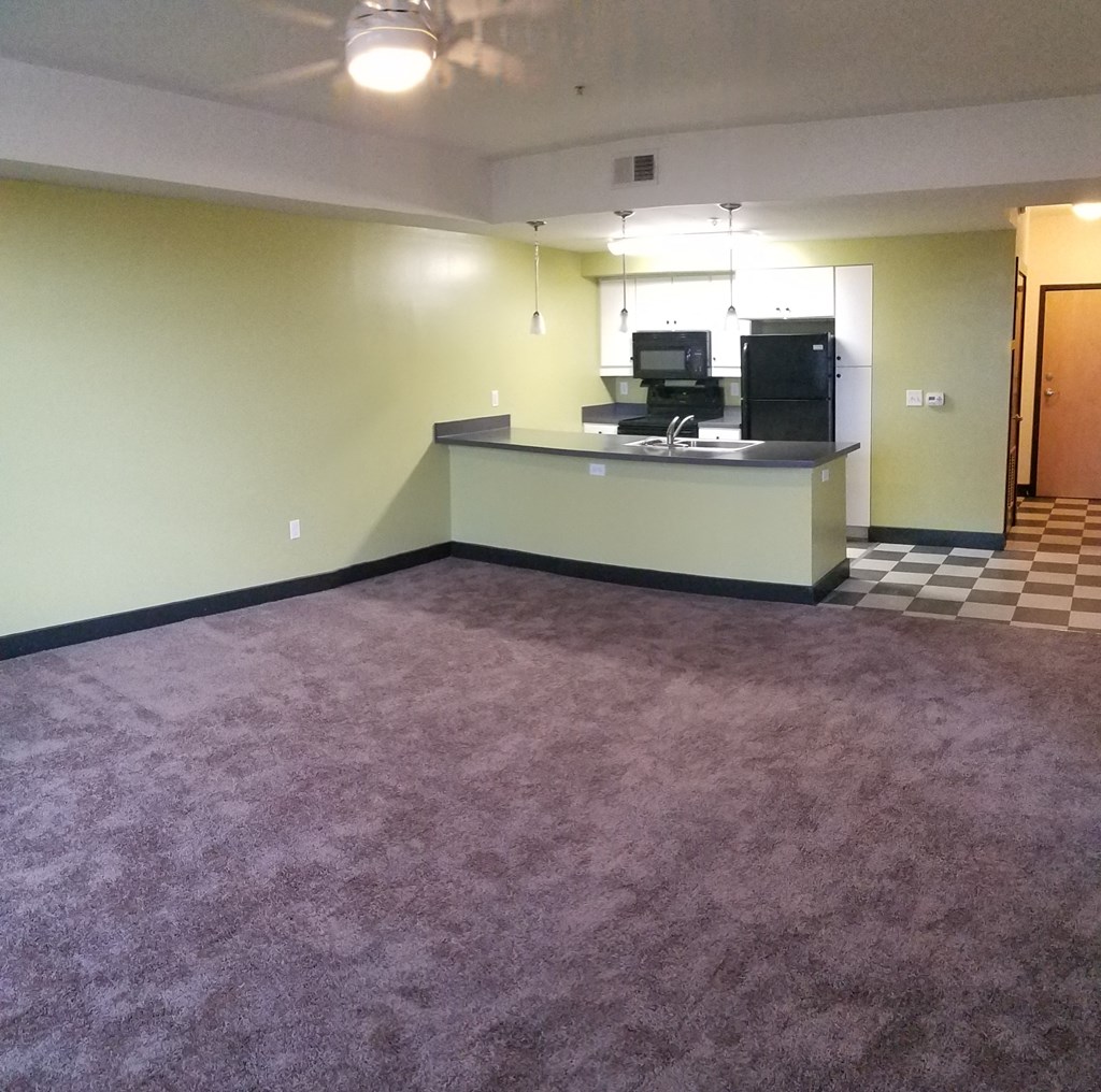 the living room and kitchen of an empty apartment
