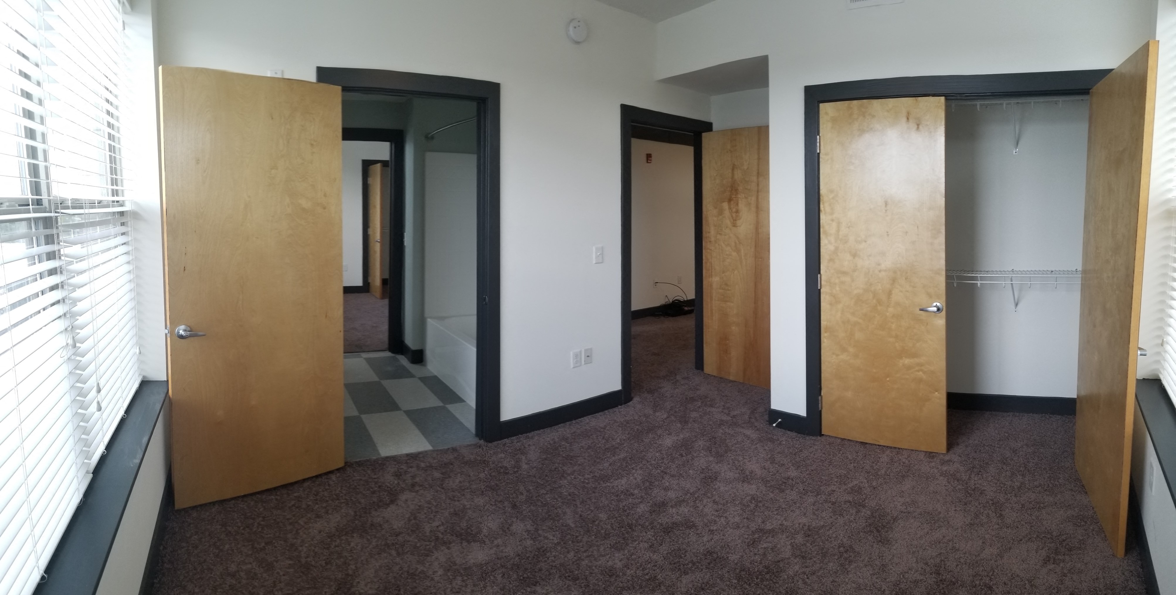 a room with four wooden doors and a carpeted floor