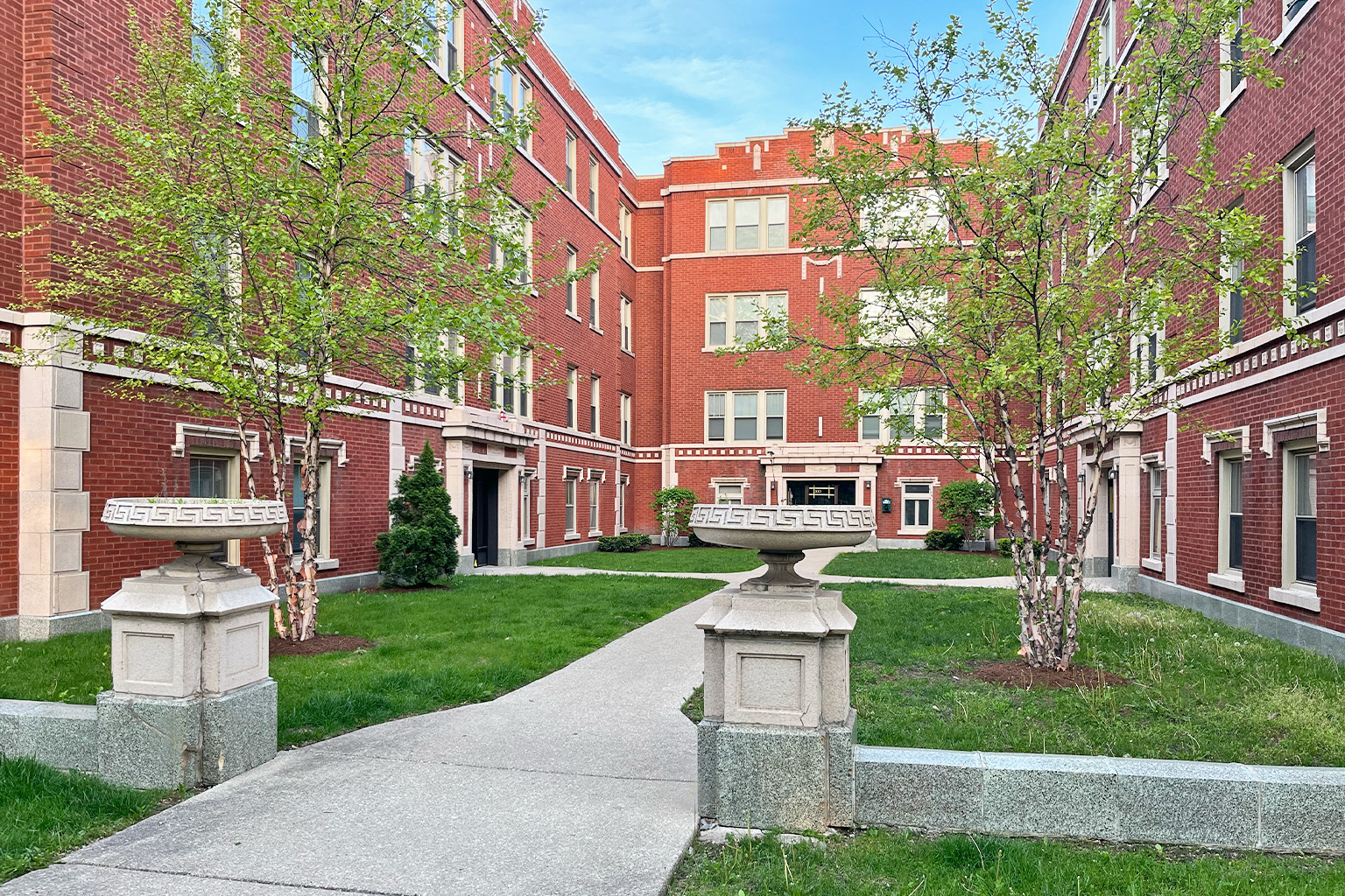 A red brick building with a walkway in front.