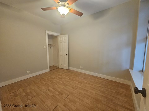 the living room with hardwood flooring and a ceiling fan