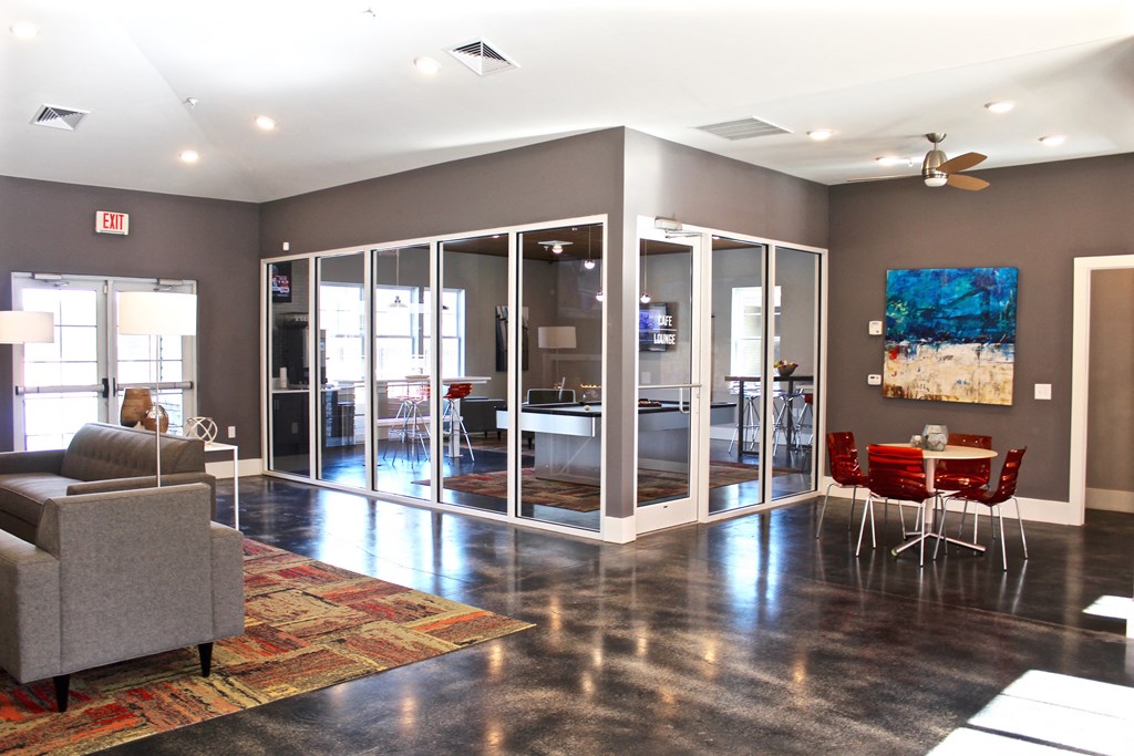 a living room with a couch and chairs and a dining room with glass doors