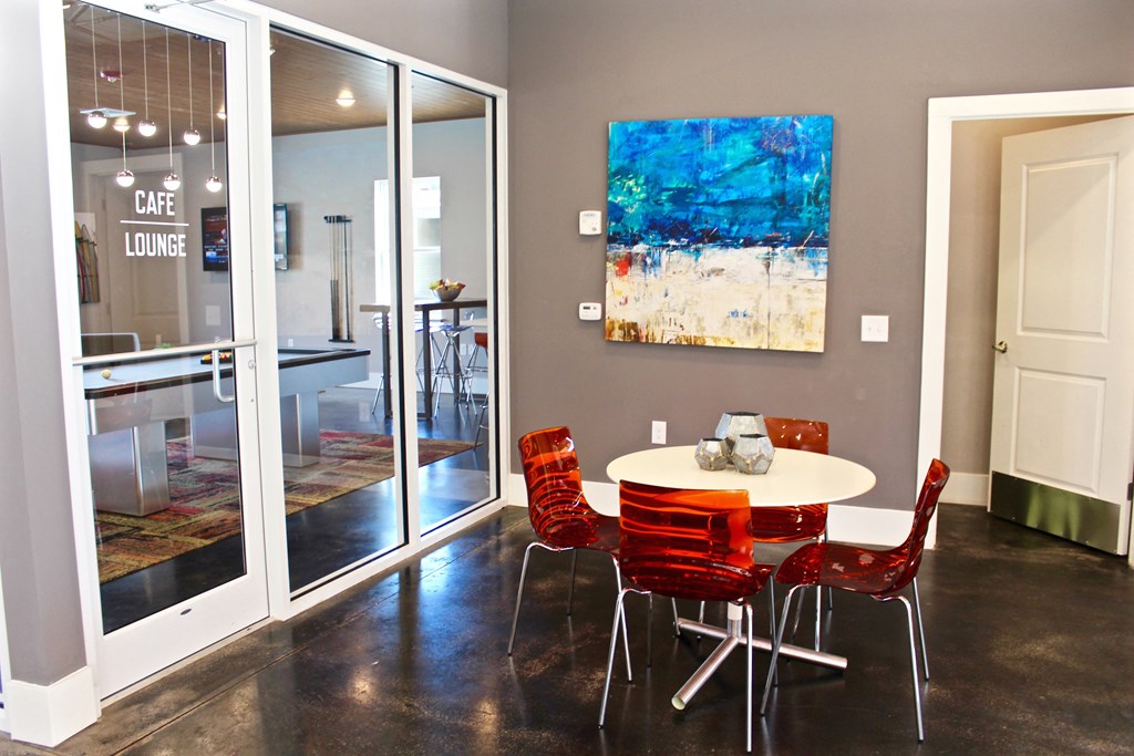 a dining room with a table and chairs and a painting on the wall