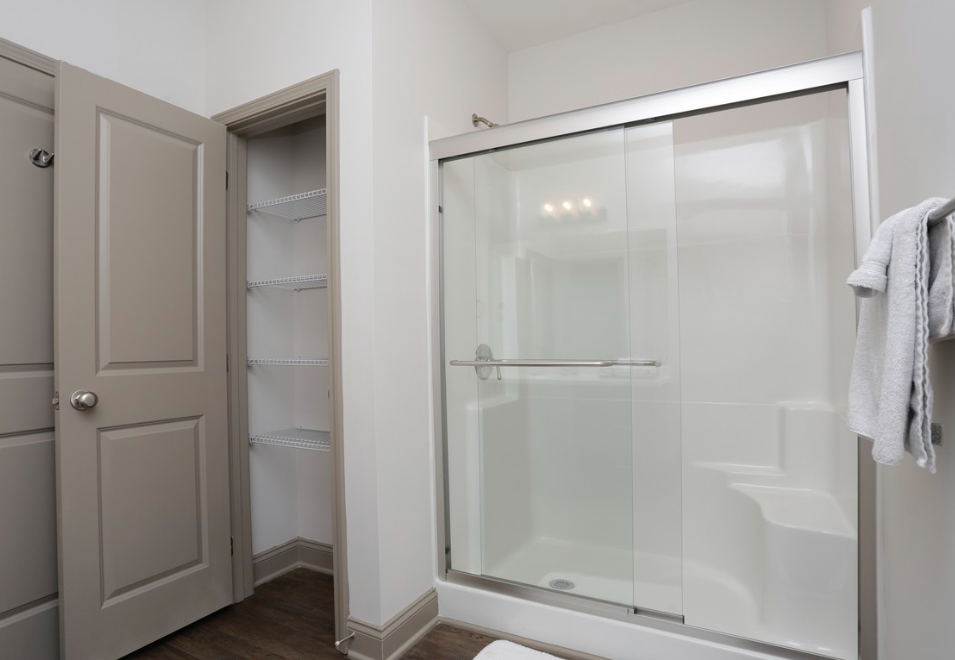 a bathroom with a glass shower and a white door