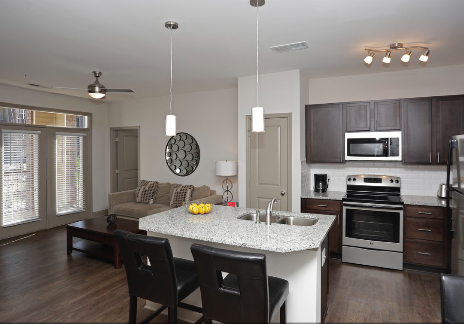 a kitchen and living room with a marble counter top