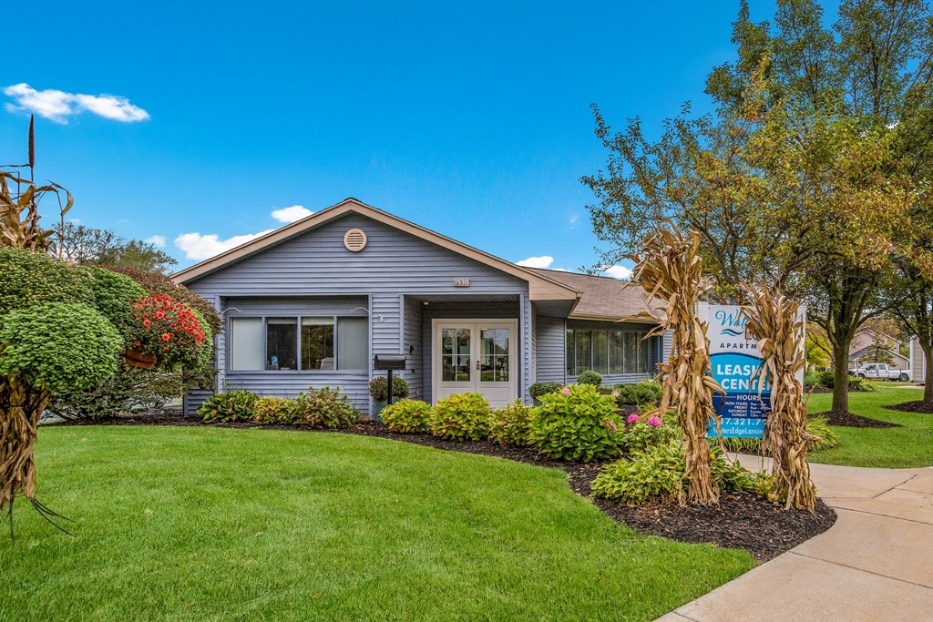 a blue house with a yard and a yard sale sign
