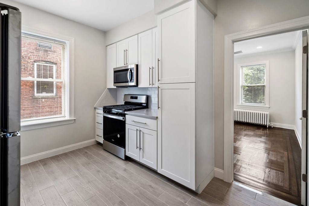 a kitchen with white cabinets and a microwave